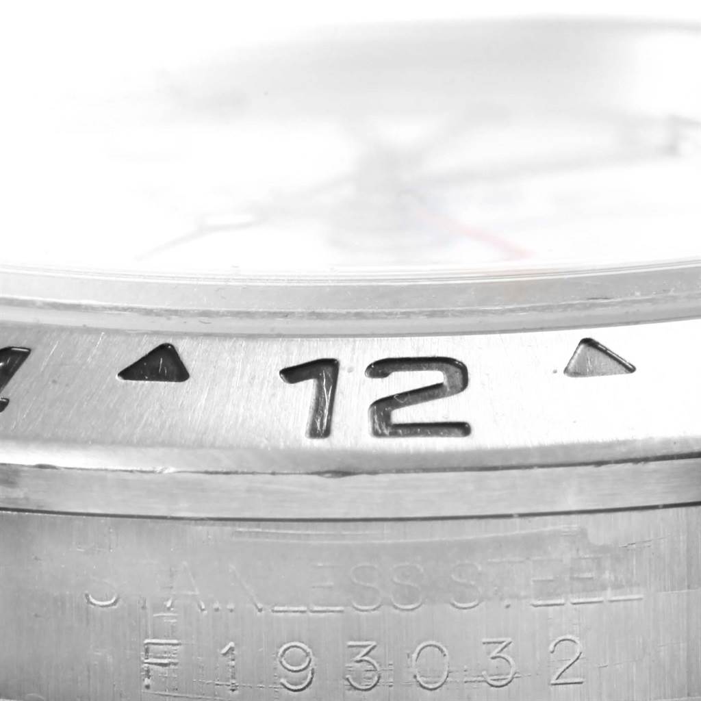 This close-up image of the Rolex Explorer 16570 Men's Stainless Steel White Dial 16570 Men's Stainless Steel White Dial watch shows the bezel, part of the dial, and serial number on the stainless steel case.