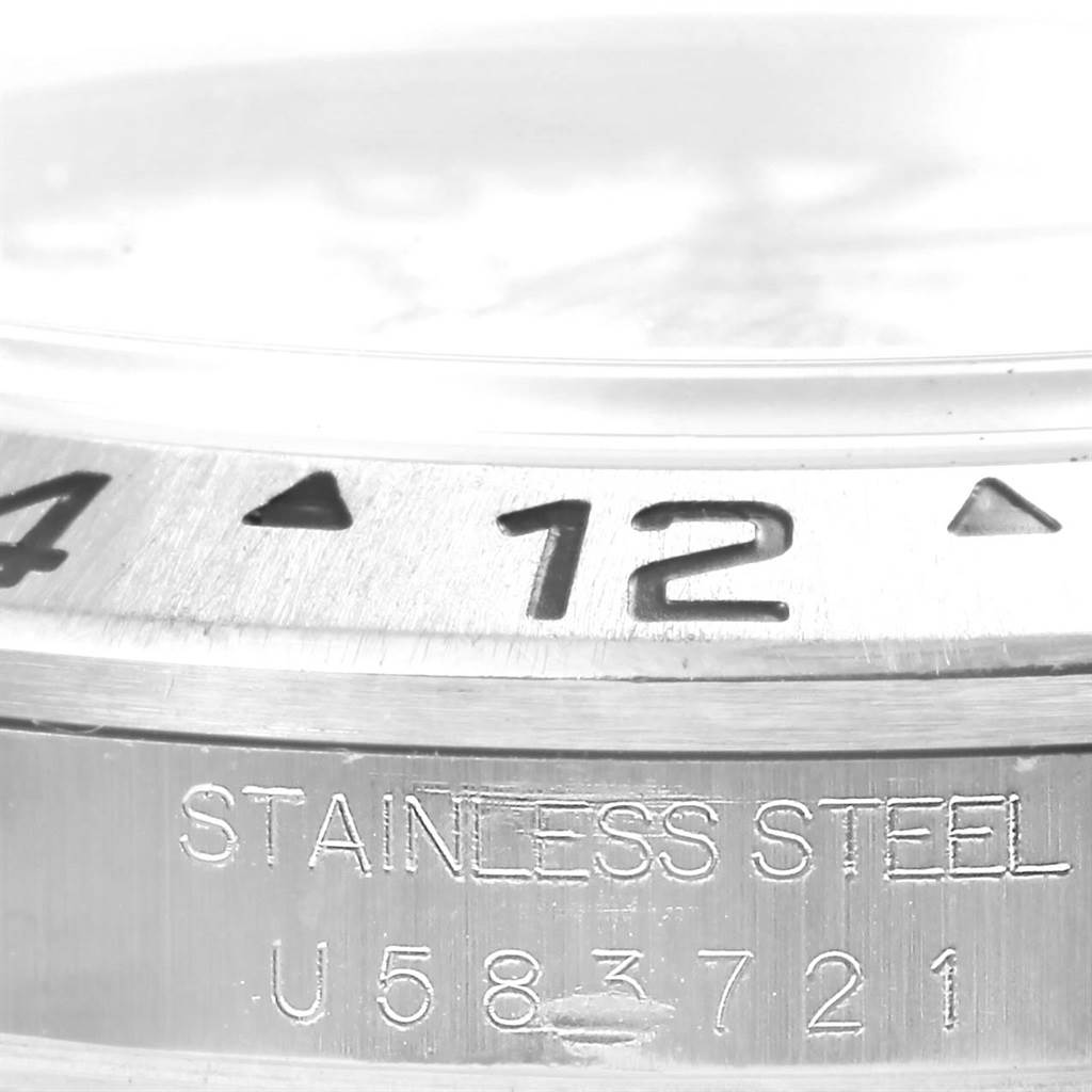 The image shows a close-up view of the stainless steel bezel and part of the case of a Rolex Explorer 16570 Men's Stainless Steel White Dial 16570 Men's Stainless Steel White Dial watch.