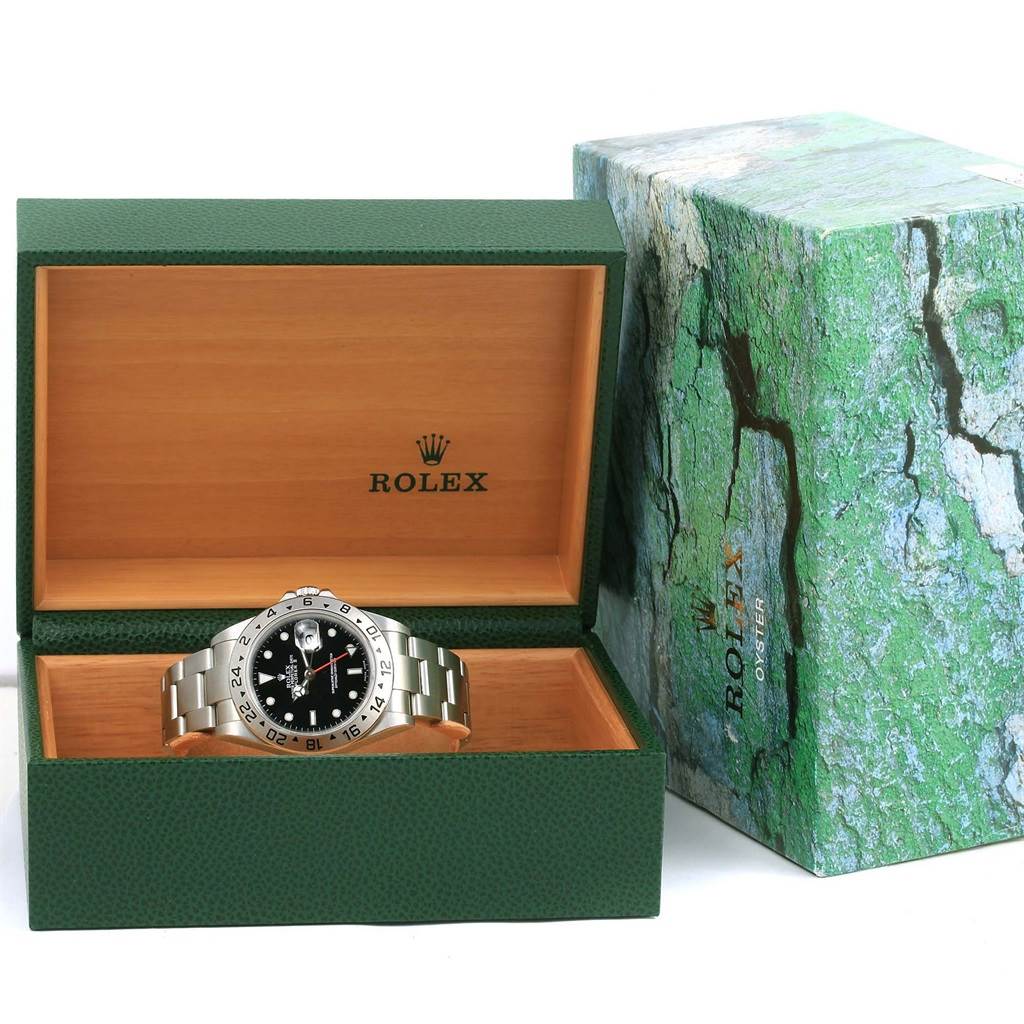 The Rolex Explorer 16570 Men's Stainless Steel Black Dial 16570 Men's Stainless Steel Black Dial model watch is displayed inside an open green and wooden box, with the green outer box beside it.