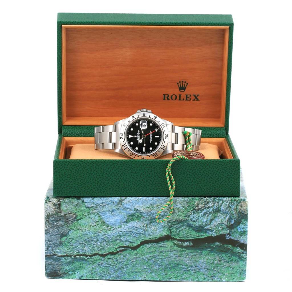 The Rolex Explorer 16570 Men's Stainless Steel Black Dial 16570 Men's Stainless Steel Black Dial watch is displayed front-facing inside its open green and wooden box, showcasing the dial and bracelet.
