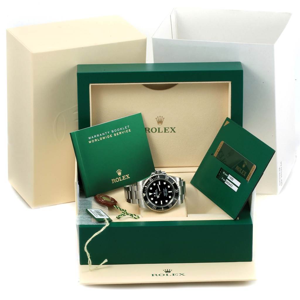 The Rolex Explorer 114060 Men's Stainless Steel Black Dial 114060 Men's Stainless Steel Black Dial watch is displayed in its box with accompanying warranty booklet and card.