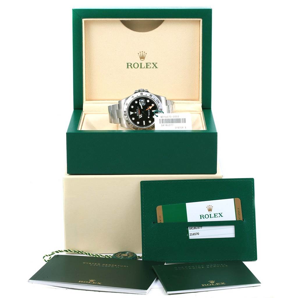 This image shows the Rolex Explorer 216570 Men's Stainless Steel Black Dial 216570 Men's Stainless Steel Black Dial watch, its open box, warranty card, and associated documentation from a front angle.