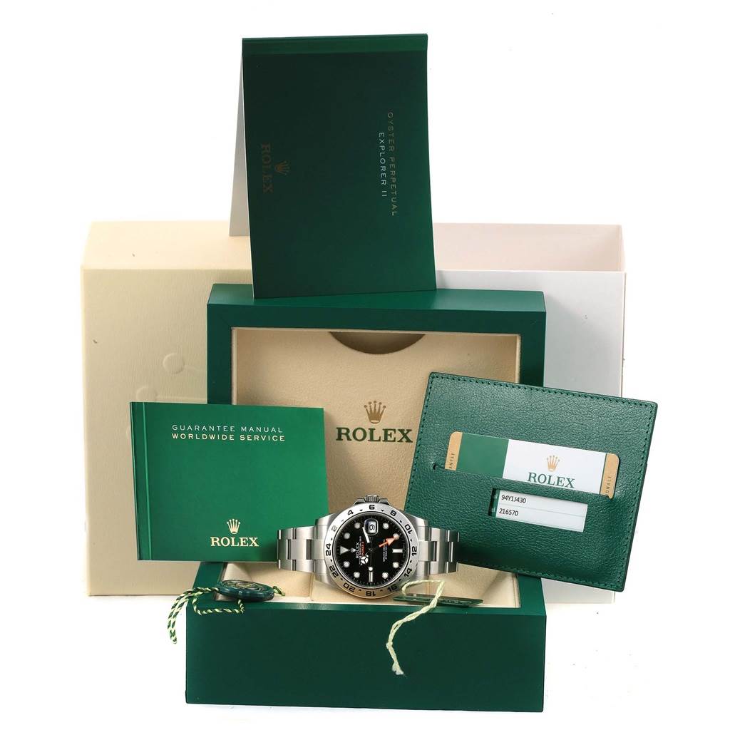 The image shows a Rolex Explorer 216570 Men's Stainless Steel Black Dial 216570 Men's Stainless Steel Black Dial watch with its box, manual, and warranty card.