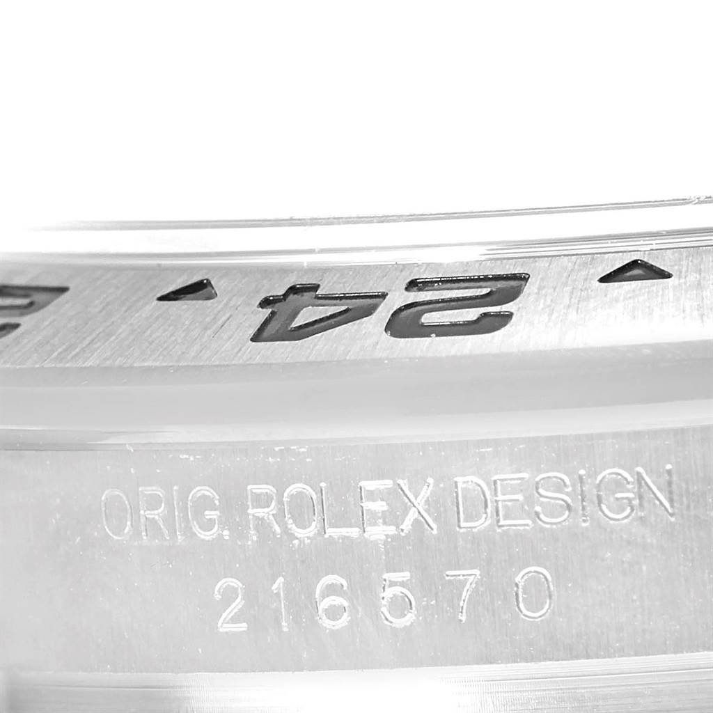 The image shows a close-up of the Rolex Explorer 216570 Men's Stainless Steel Black Dial 216570 Men's Stainless Steel Black Dial’s bezel and the engraved model number 216570.