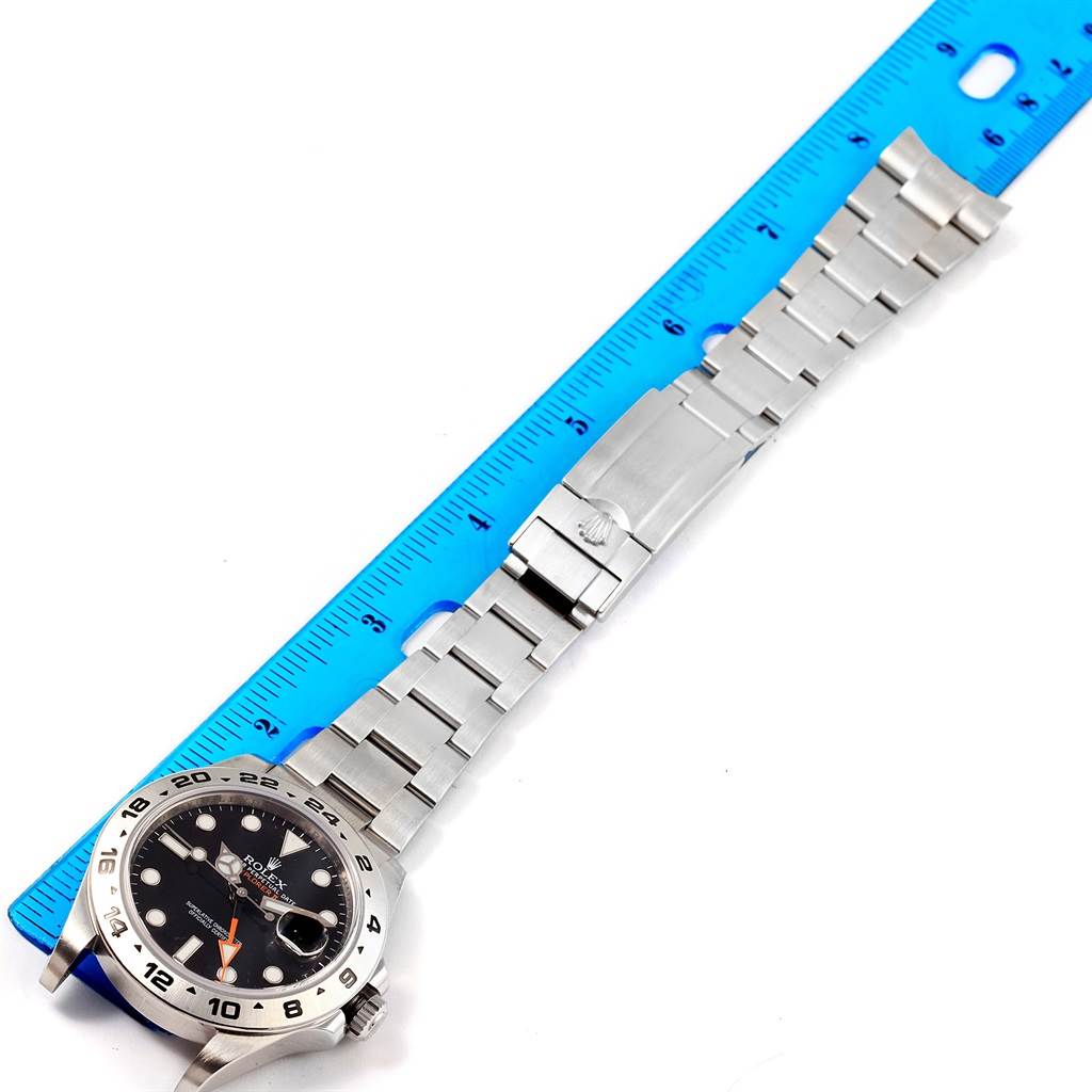 The image shows a Rolex Explorer 216570 Men's Stainless Steel Black Dial 216570 Men's Stainless Steel Black Dial watch laid flat with its bracelet along a blue ruler for measurement.
