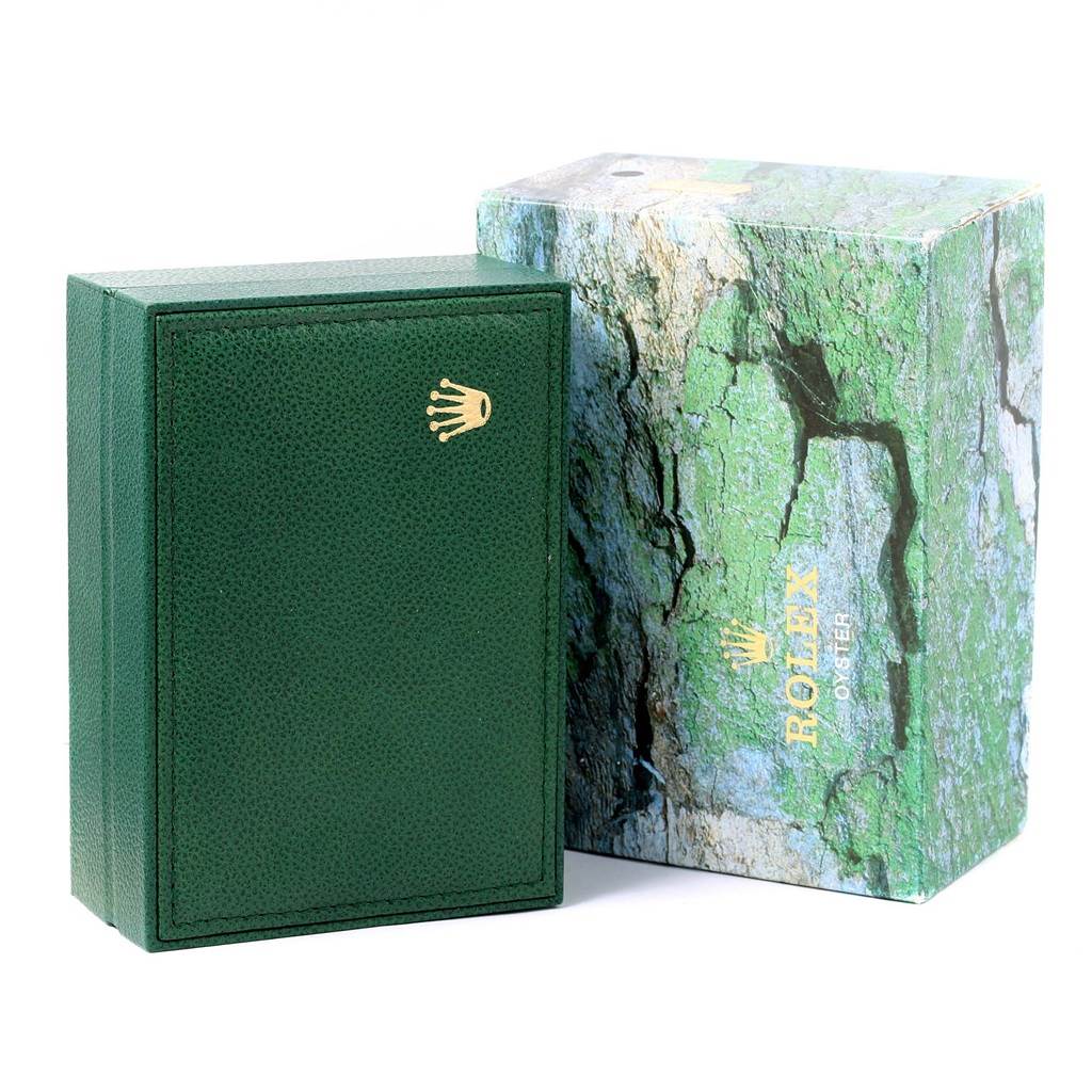 The image shows a green Rolex watch box and its outer packaging, specifically for the Explorer model.