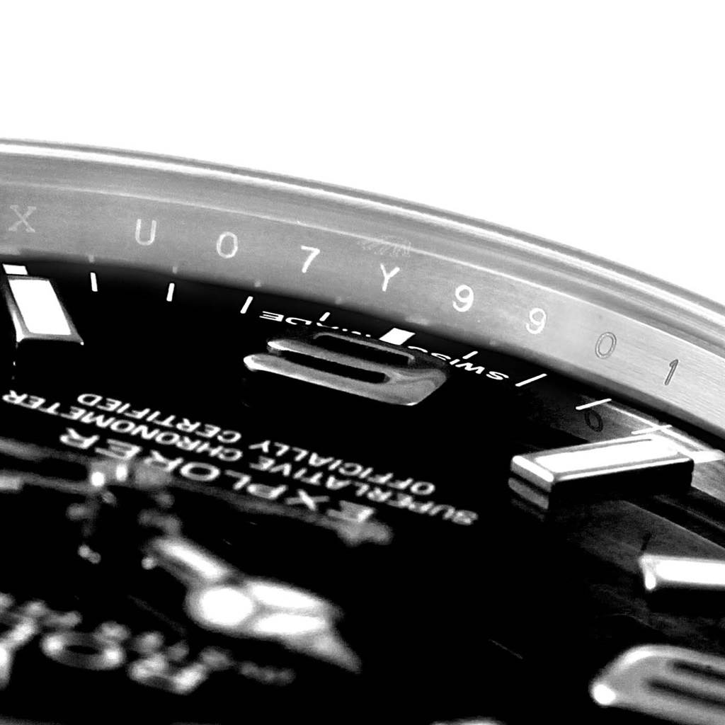Close-up shot of a Rolex Explorer 214270 Men's Stainless Steel Black Dial 214270 Men's Stainless Steel Black Dial watch showing part of the dial and inner bezel with serial numbers.