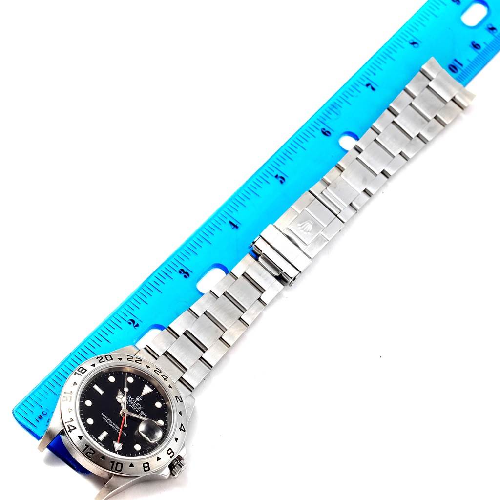 This image shows a top-down view of a Rolex Explorer 16570 Men's Stainless Steel Black Dial 16570 Men's Stainless Steel Black Dial watch, including the bezel, dial, and bracelet, measured with a blue ruler.