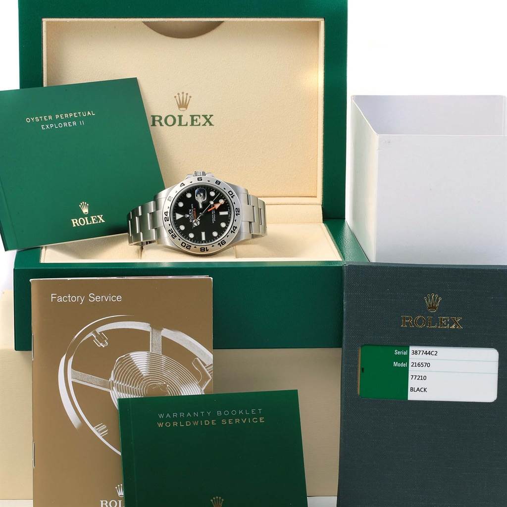 The image shows a Rolex Explorer 216570 Men
s Stainless Steel Black Dial 216570 Men
s Stainless Steel Black Dial watch front-facing, with its box, warranty booklets, and service booklets.