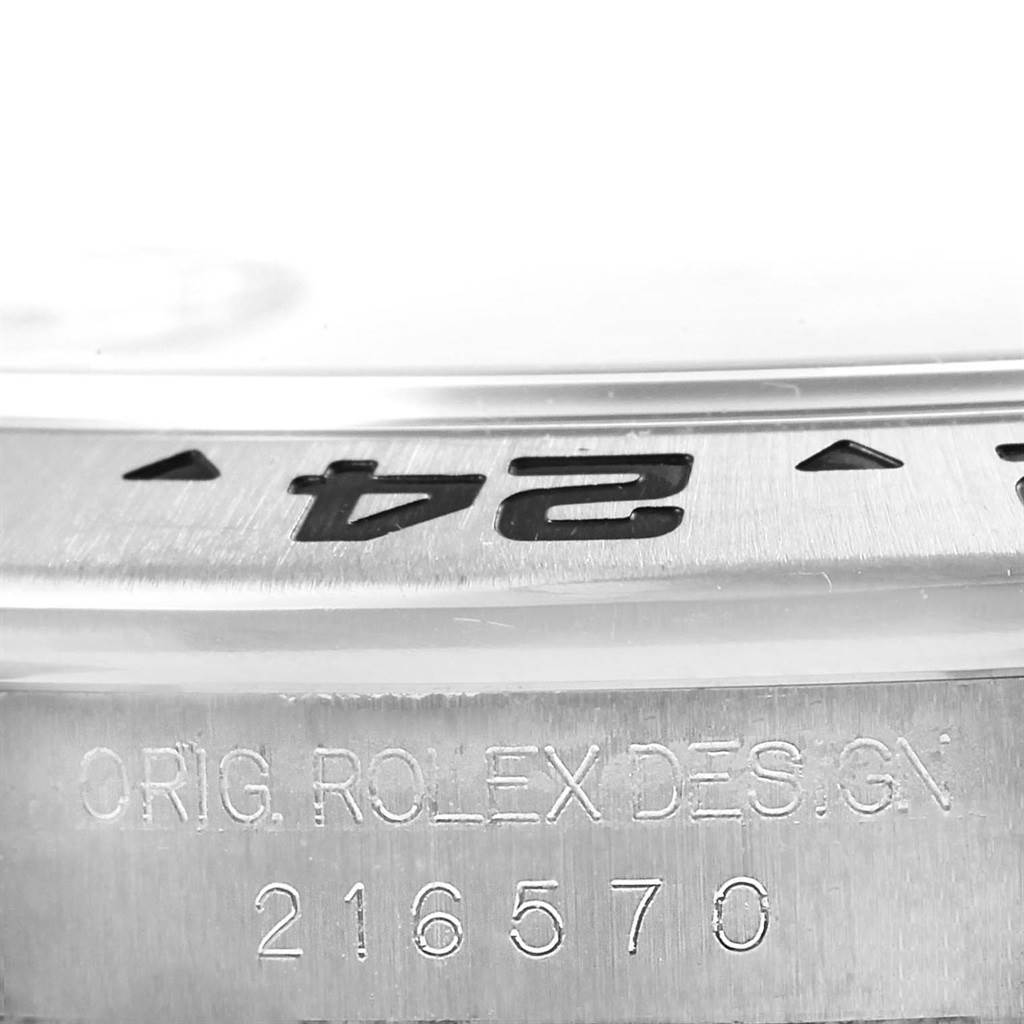 This close-up image of a Rolex Explorer 216570 Men's Stainless Steel Black Dial 216570 Men's Stainless Steel Black Dial watch shows the bezel and model engraving "216570" along with "ORIG. ROLEX DESIGN."