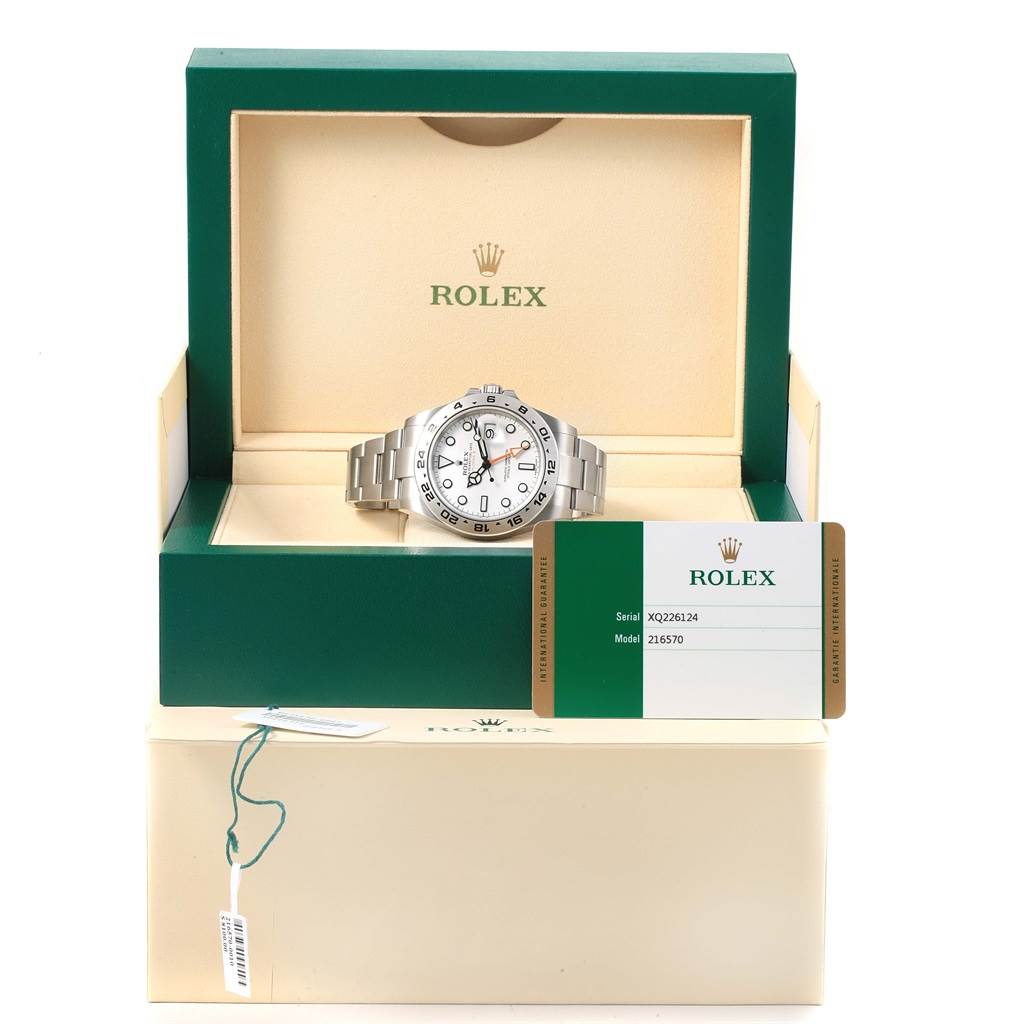 The Rolex Explorer 216570 Men's Stainless Steel White Dial 216570 Men's Stainless Steel White Dial watch is displayed at a front angle in its box, alongside its certification card.