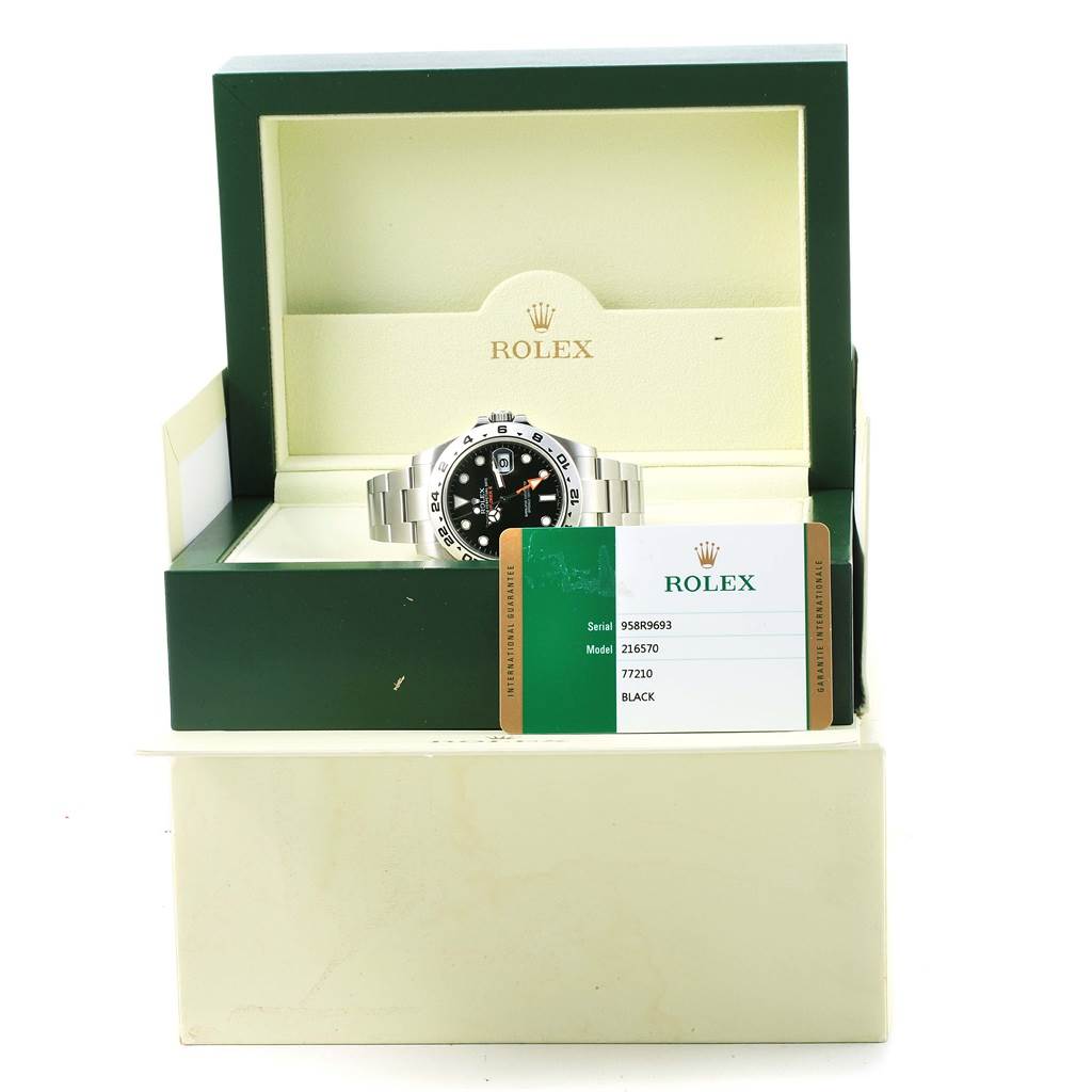 The Rolex Explorer 216570 Men's Stainless Steel Black Dial 216570 Men's Stainless Steel Black Dial watch is displayed front-on, in its box, alongside a warranty card.