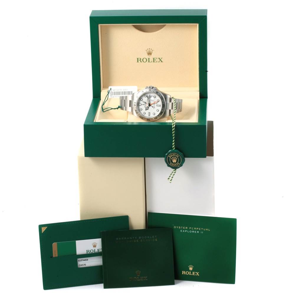 The Rolex Explorer 216570 Men's Stainless Steel White Dial 216570 Men's Stainless Steel White Dial watch is displayed in its open box with tags, manuals, and warranty card.