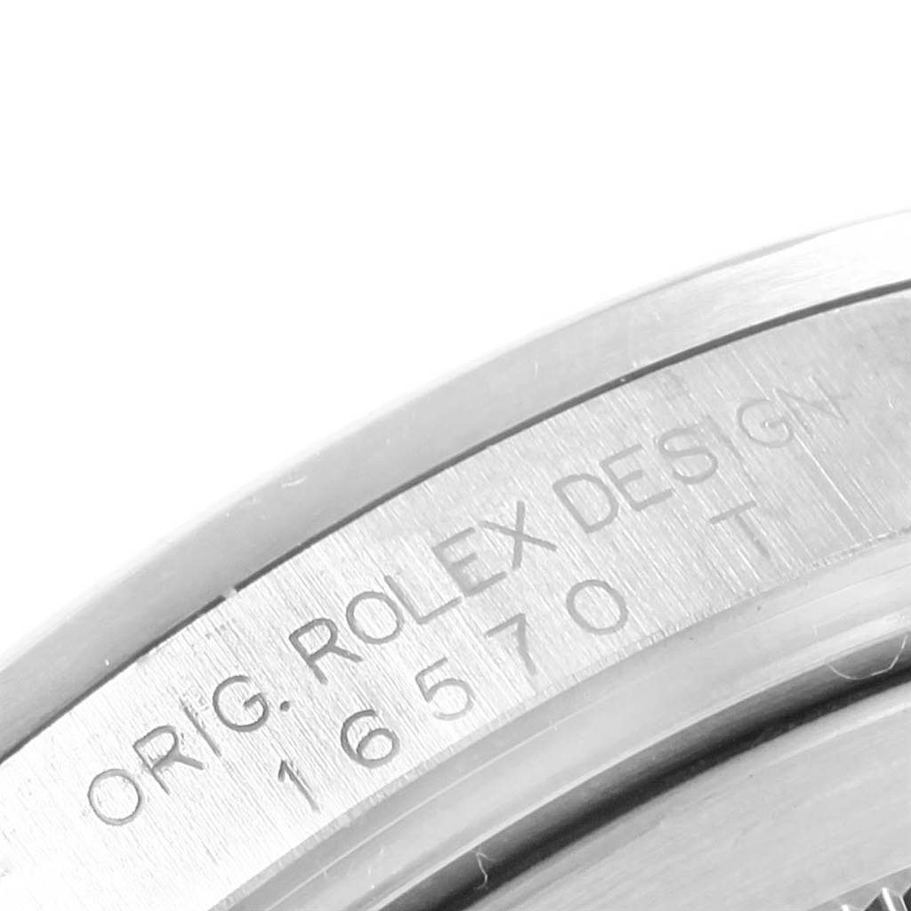 This image shows a close-up of the engraved serial number and "ORIG. ROLEX DESIGN" on the case of a Rolex Explorer 16570 Men's Stainless Steel White Dial 16570 Men's Stainless Steel White Dial model.