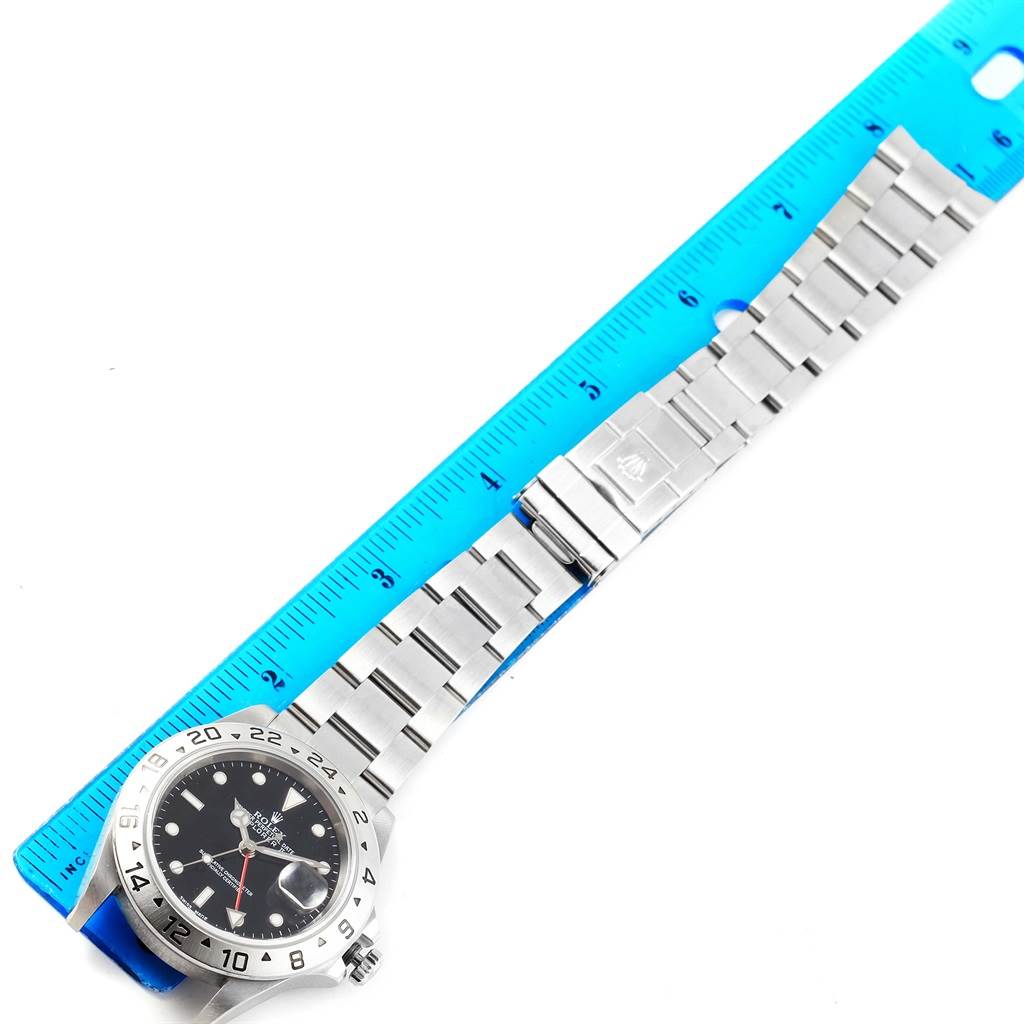 The image shows the Rolex Explorer 16570 Men's Stainless Steel Black Dial 16570 Men's Stainless Steel Black Dial watch laid flat, displaying the face, bezel, and stainless steel bracelet with a ruler for scale.