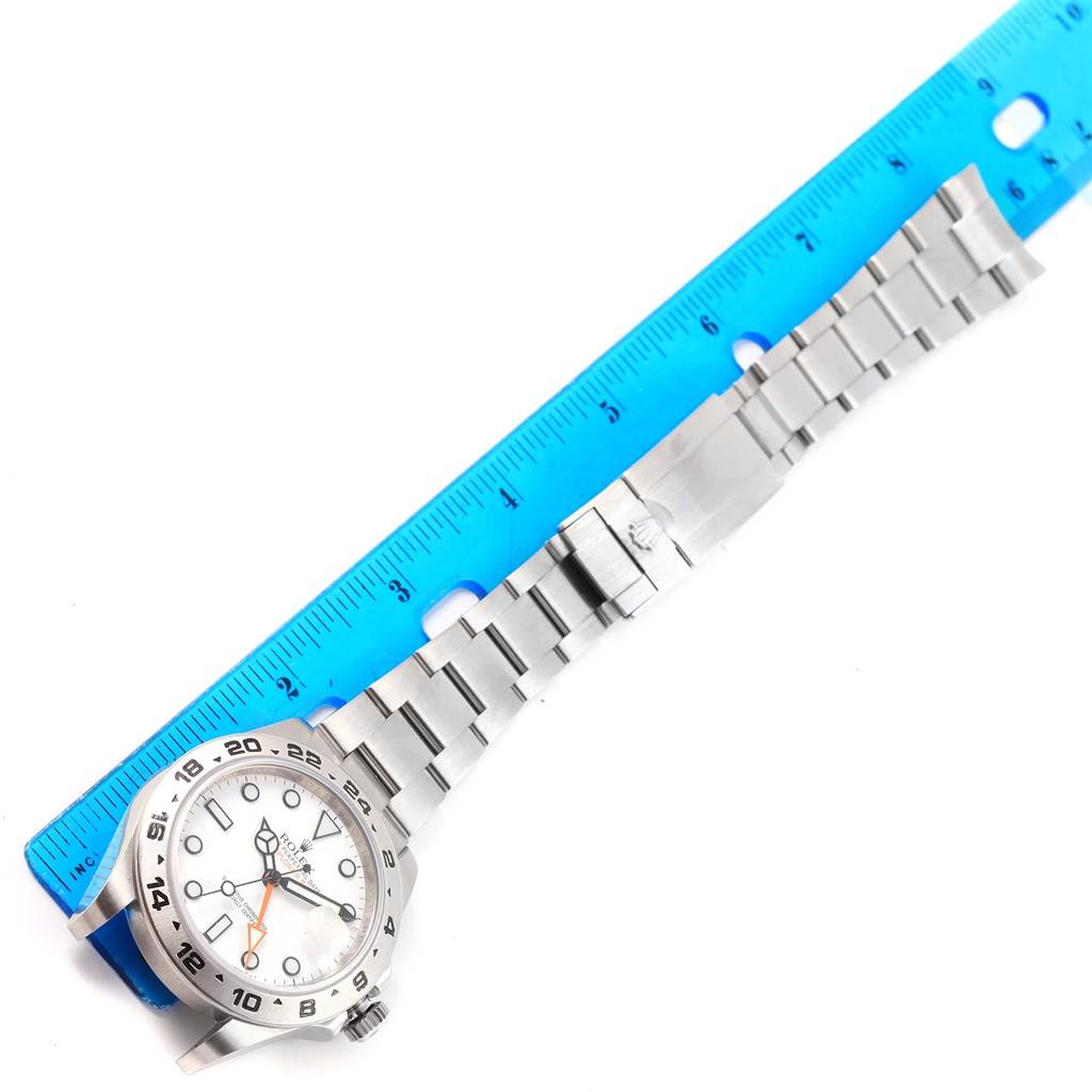 The image shows a Rolex Explorer 216570 Men's Stainless Steel White Dial 216570 Men's Stainless Steel White Dial watch laid flat with the entire band and clasp visible, measured with a blue ruler.