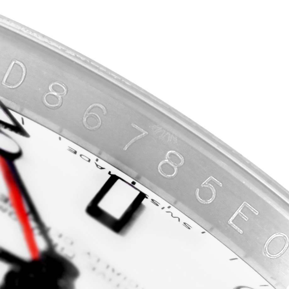 This close-up of a Rolex Explorer 16570 Men's Stainless Steel White Dial 16570 Men's Stainless Steel White Dial watch shows part of the dial and the engraved serial number on the bezel.