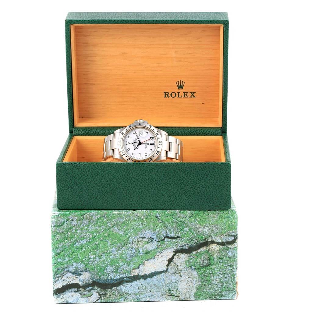 This image shows a front view of a Rolex Explorer 16570 Men's Stainless Steel White Dial 16570 Men's Stainless Steel White Dial watch inside an open green and wood Rolex box.