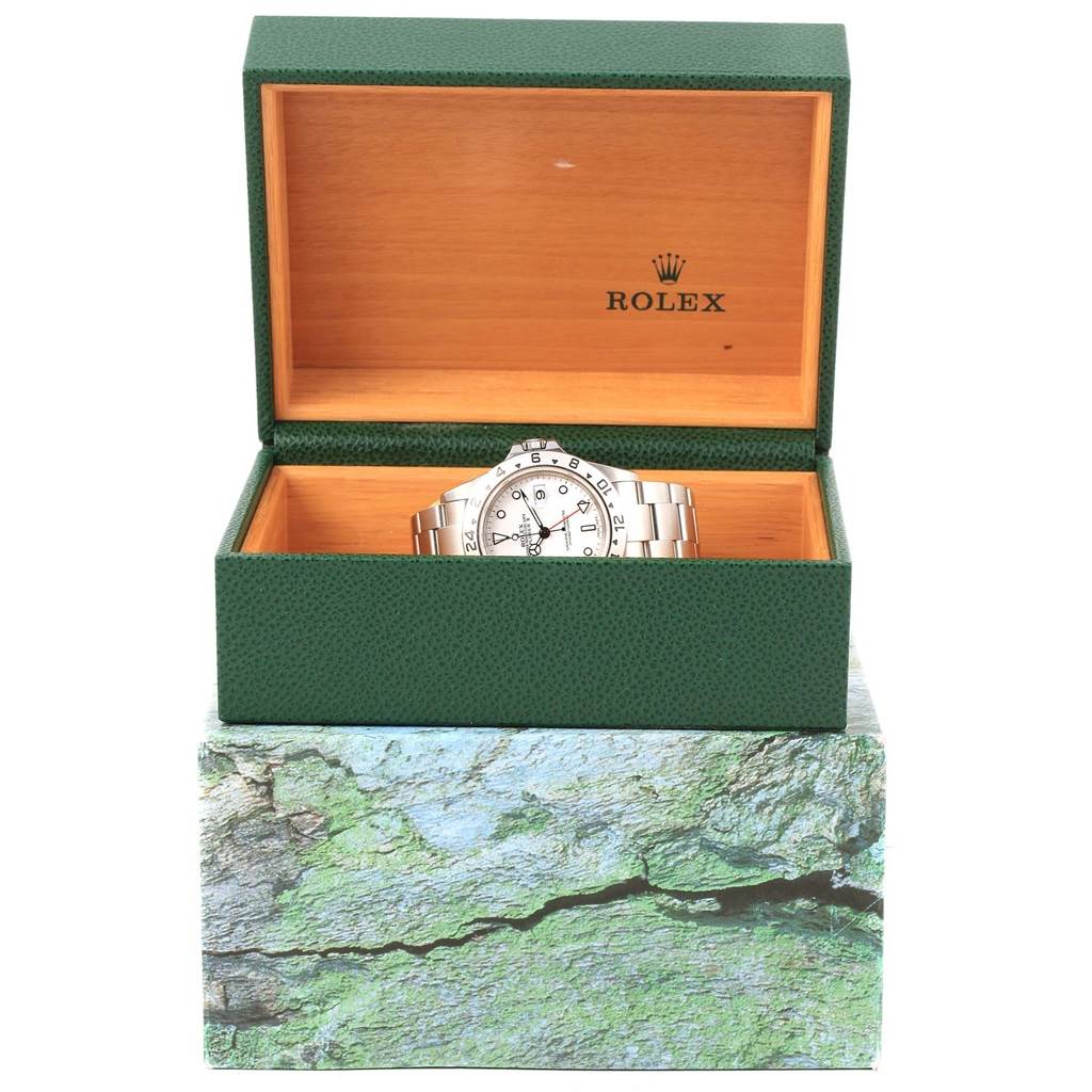 The Rolex Explorer 16570 Men's Stainless Steel White Dial 16570 Men's Stainless Steel White Dial watch is displayed in an open green box with a wooden interior, viewed from the front.