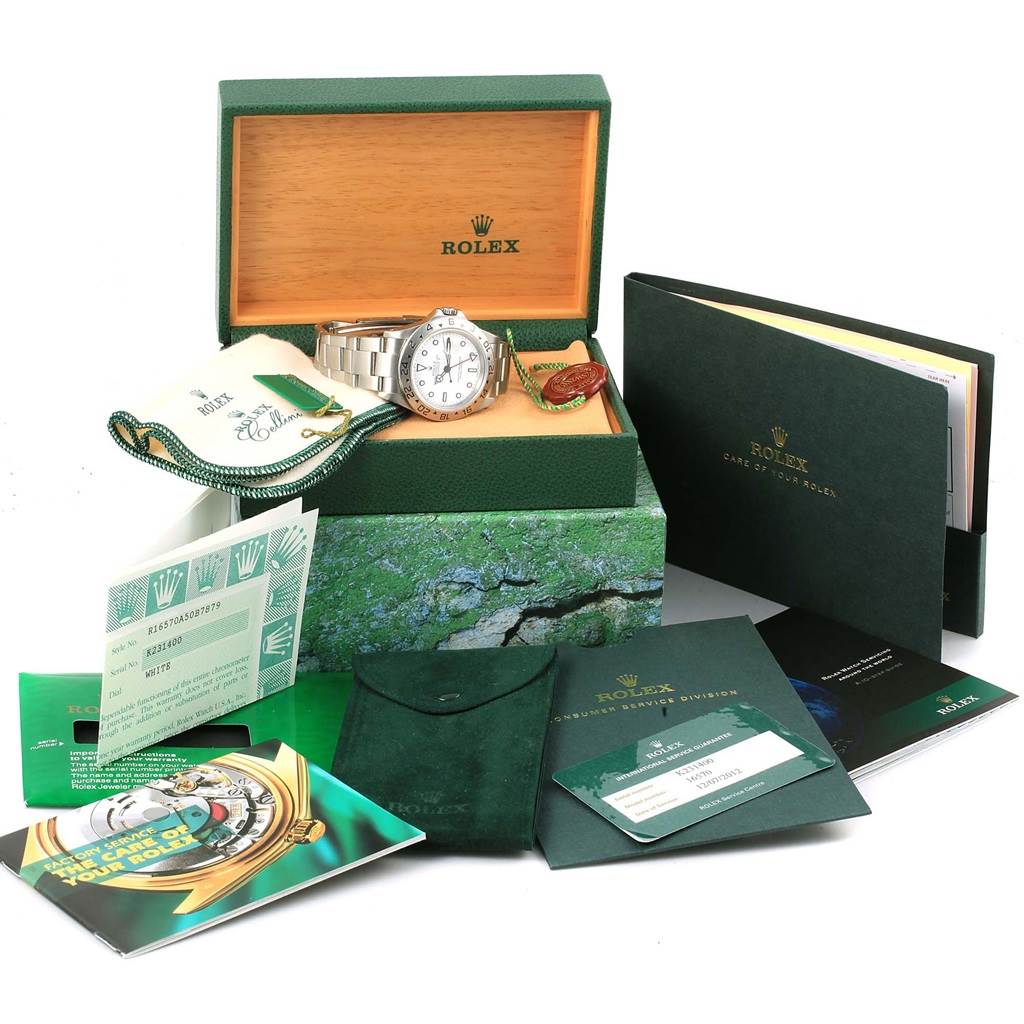 The Rolex Explorer 16570 Men's Stainless Steel White Dial 16570 Men's Stainless Steel White Dial watch is shown at a slight angle inside a box surrounded by manuals, a pouch, and authenticity documents.