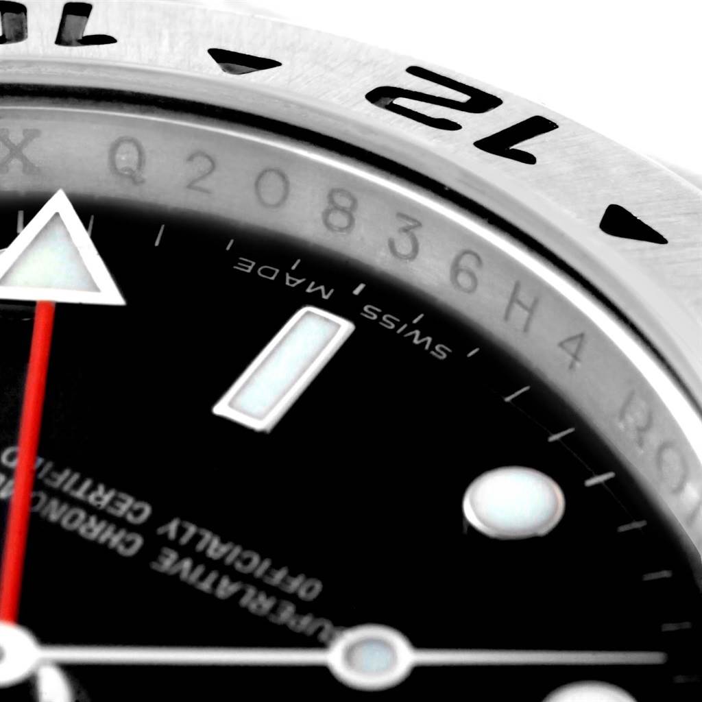 Close-up of the Rolex Explorer 16570 Men's Stainless Steel Black Dial 16570 Men's Stainless Steel Black Dial watch showing part of the bezel, dial, and hands, including a red second or GMT hand.