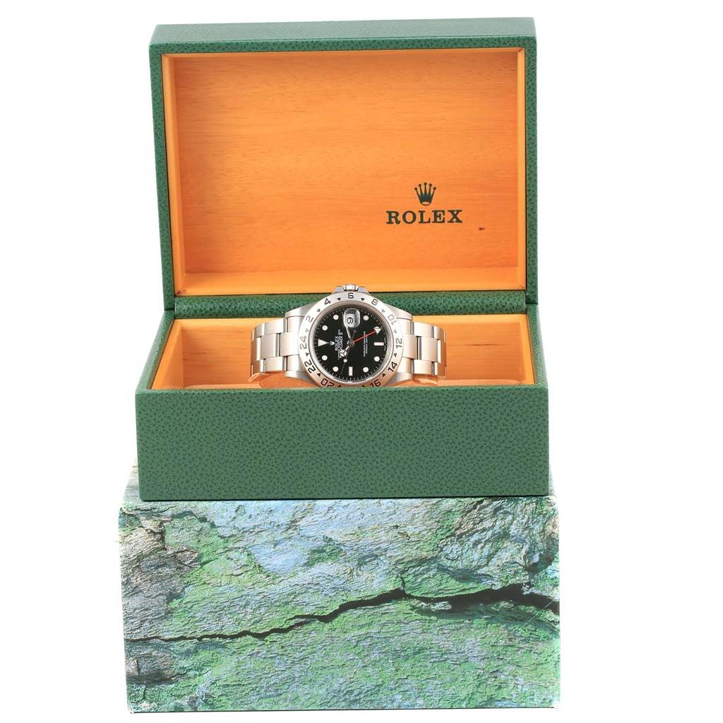 The Rolex Explorer 16570 Men's Stainless Steel Black Dial 16570 Men's Stainless Steel Black Dial watch is shown from the front inside its green and orange branded box.