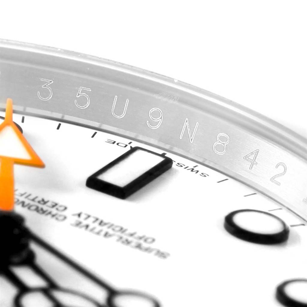 This close-up shows a portion of the Rolex Explorer 216570 Men's Stainless Steel White Dial 216570 Men's Stainless Steel White Dial watch face, highlighting the hour markers and part of the serial number.