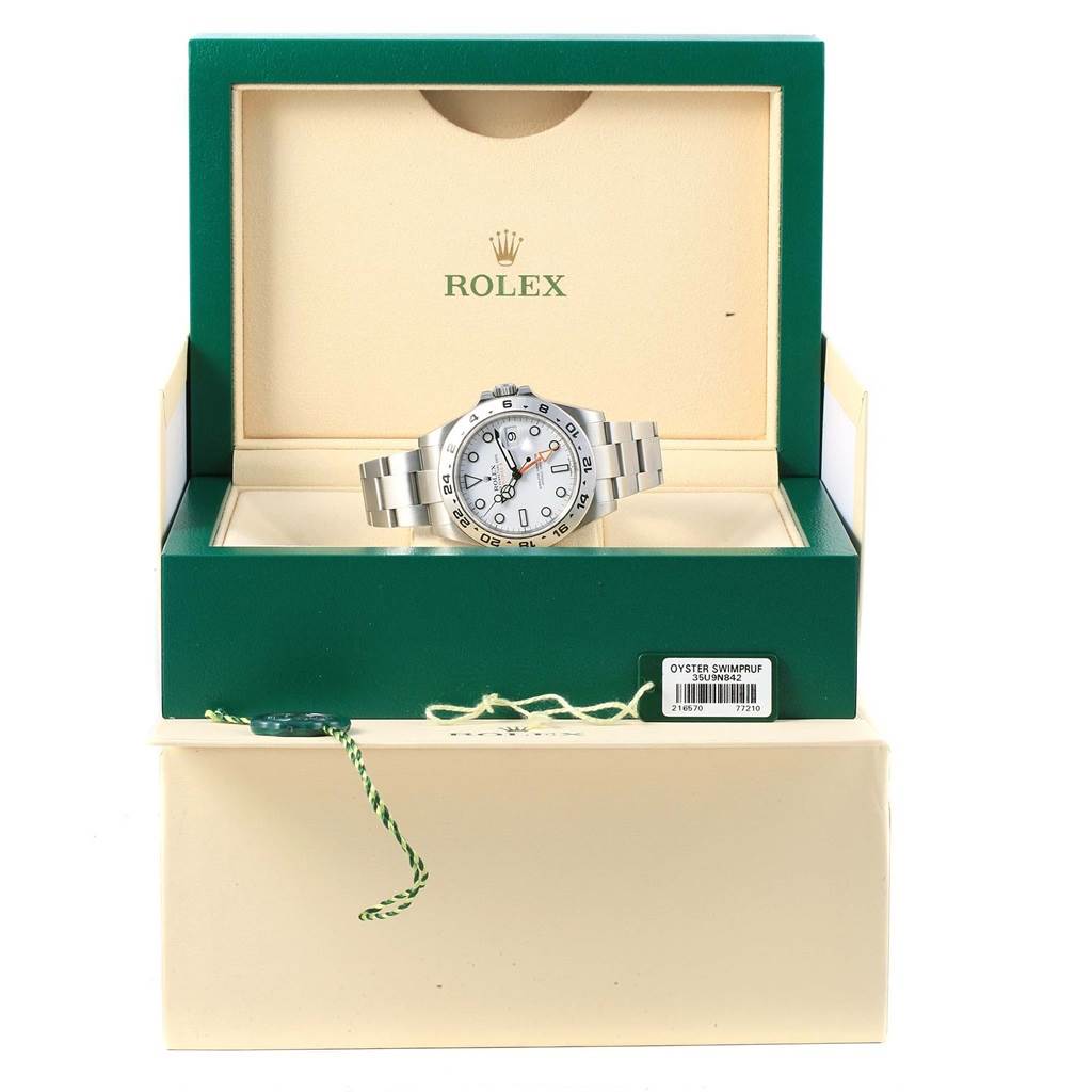 The Rolex Explorer 216570 Men's Stainless Steel White Dial 216570 Men's Stainless Steel White Dial watch is shown from the front, displayed in an open green and beige Rolex box.