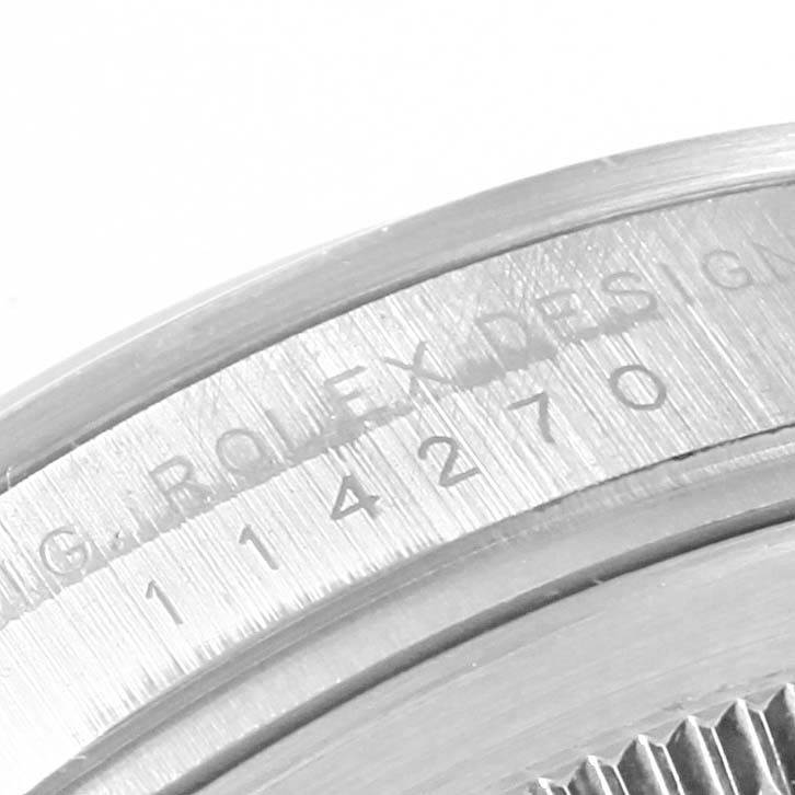 This image shows a close-up of the engraved serial number and design marking on the case of a Rolex Explorer 114270 Men's Stainless Steel Black Dial 114270 Men's Stainless Steel Black Dial watch.