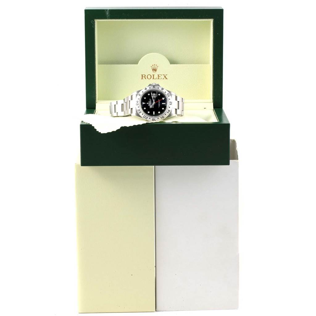 The Rolex Explorer 16570 Men's Stainless Steel Black Dial 16570 Men's Stainless Steel Black Dial watch is displayed front-on, positioned within its open green and cream-colored box.