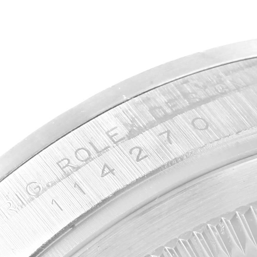 The image shows a close-up of the engraved bezel and caseback of the Explorer model by Rolex.