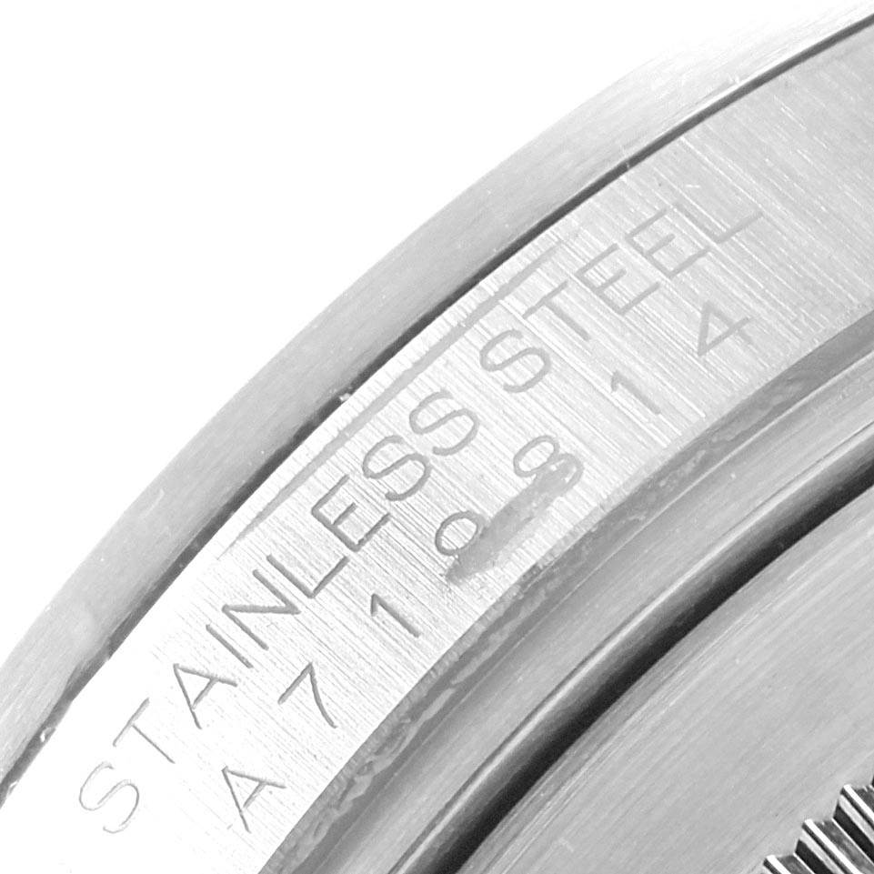 The image shows a close-up of the case engraving on a Rolex Explorer 16570 Men's Stainless Steel Black Dial 16570 Men's Stainless Steel Black Dial watch, highlighting the "Stainless Steel" marking and serial number.