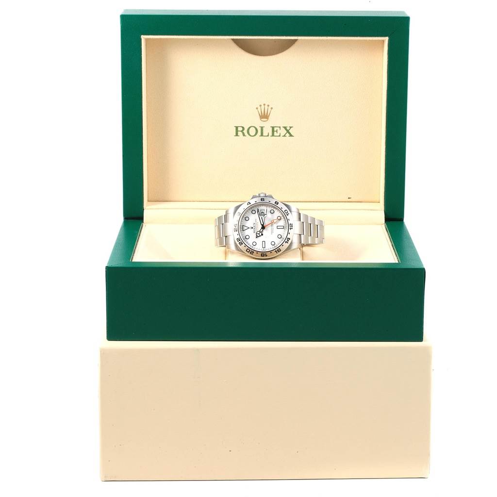 The Rolex Explorer 216570 Men's Stainless Steel White Dial 216570 Men's Stainless Steel White Dial watch is shown in its open green and cream-colored box, viewed from the front.