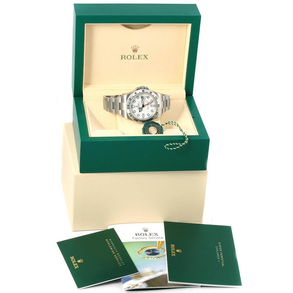 The Rolex Explorer 216570 Men's Stainless Steel White Dial 216570 Men's Stainless Steel White Dial watch is displayed in an open green case with accompanying booklets and a green tag.