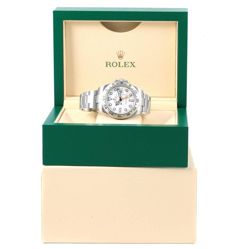 The Rolex Explorer 216570 Men's Stainless Steel White Dial 216570 Men's Stainless Steel White Dial watch is shown front-facing, within its open green and beige display box.