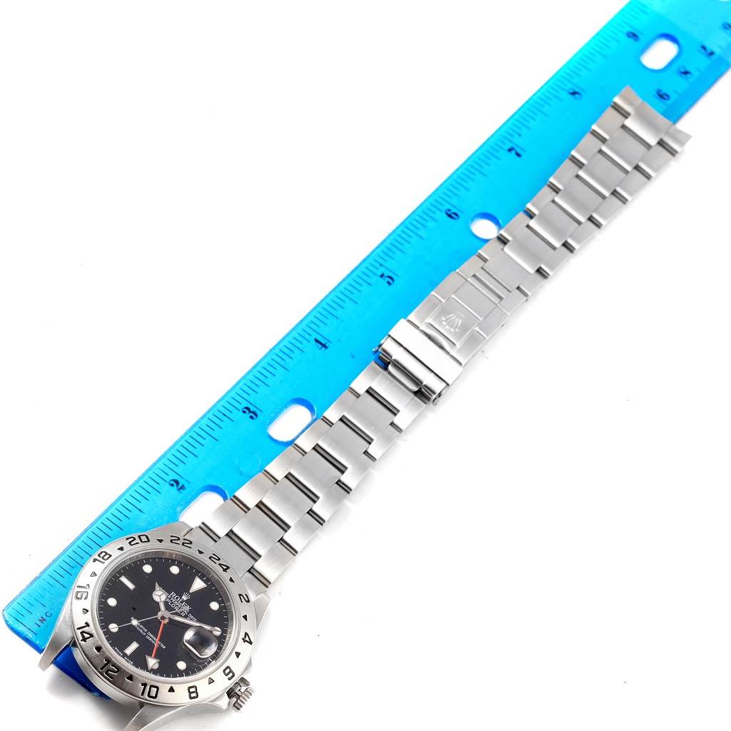 The image shows a flat-laid Rolex Explorer 16570 Men's Stainless Steel Black Dial 16570 Men's Stainless Steel Black Dial watch, with a blue ruler for scale.