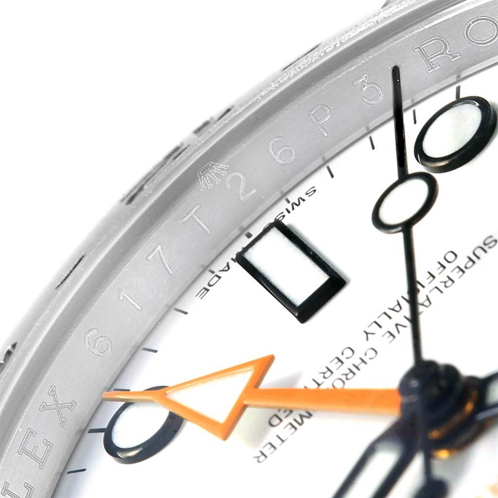 Close-up of a Rolex Explorer 216570 Men's Stainless Steel White Dial 216570 Men's Stainless Steel White Dial showing the bezel engraving, part of the dial, and hands.