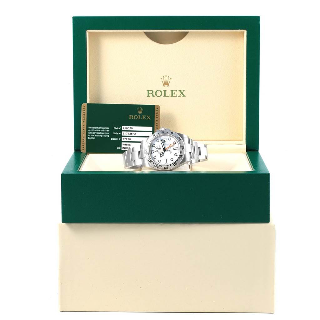 The Rolex Explorer 216570 Men's Stainless Steel White Dial 216570 Men's Stainless Steel White Dial watch is displayed in an open green box, with its authenticity card visible beside it.