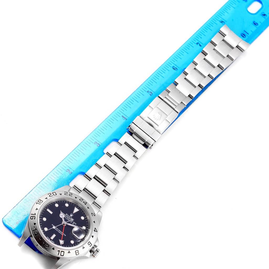 The image shows a Rolex Explorer 16570 Men's Stainless Steel Black Dial 16570 Men's Stainless Steel Black Dial watch laid flat next to a ruler, highlighting the watch face, bezel, bracelet, and clasp.