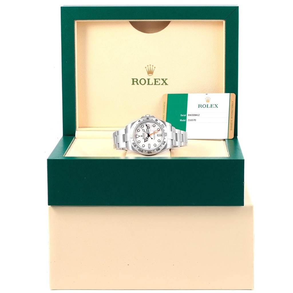 The Rolex Explorer 216570 Men's Stainless Steel White Dial 216570 Men's Stainless Steel White Dial watch is displayed in its open green box with tags visible beside it.
