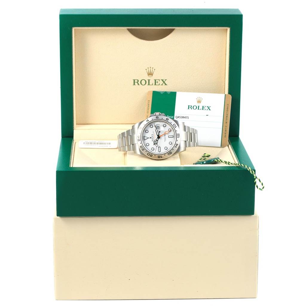 The Rolex Explorer 216570 Men's Stainless Steel White Dial 216570 Men's Stainless Steel White Dial watch is shown from the front sitting in an open green box, accompanied by its certification card.
