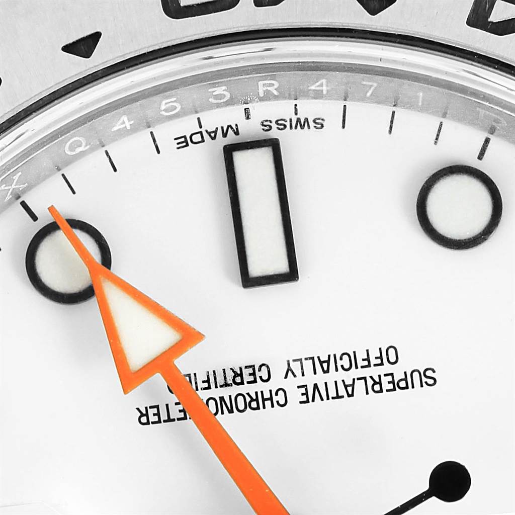 Close-up of the dial of a Rolex Explorer 216570 Men's Stainless Steel White Dial 216570 Men's Stainless Steel White Dial watch showing the orange hand, hour markers, and part of the bezel.