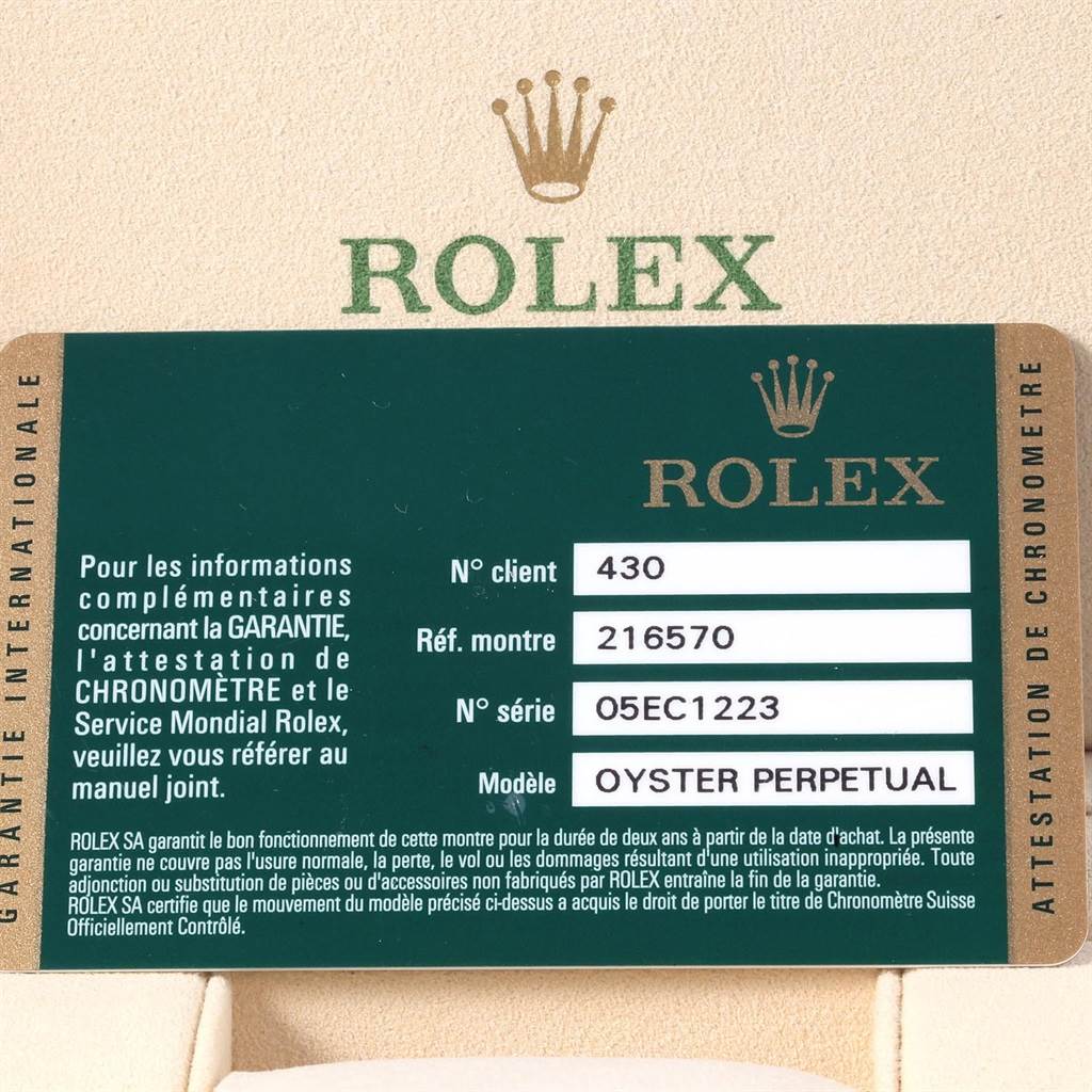 The image shows a warranty card for the Rolex Explorer 216570 Men's Stainless Steel White Dial 216570 Men's Stainless Steel White Dial model, displaying reference, serial numbers, and text in French.
