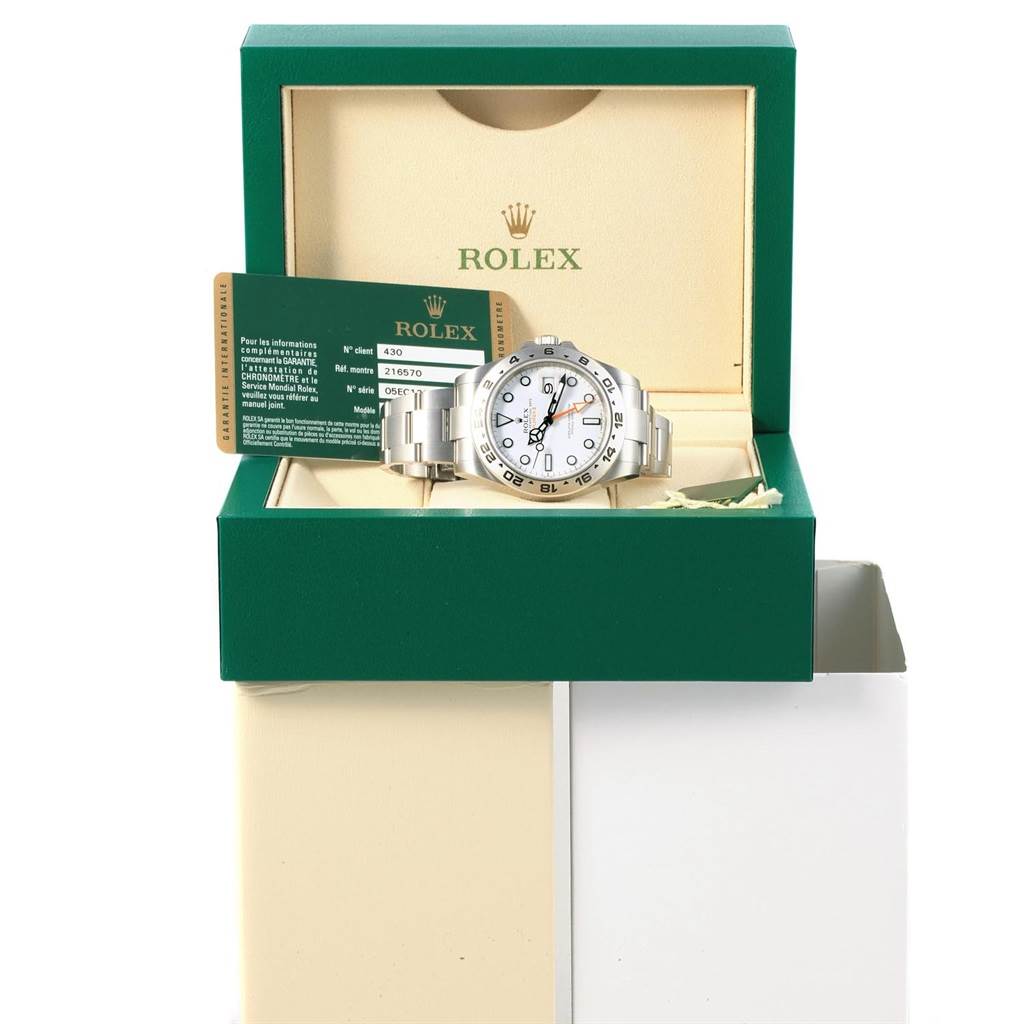 The image shows a Rolex Explorer 216570 Men's Stainless Steel White Dial 216570 Men's Stainless Steel White Dial watch displayed frontally in its open box alongside authentication cards.