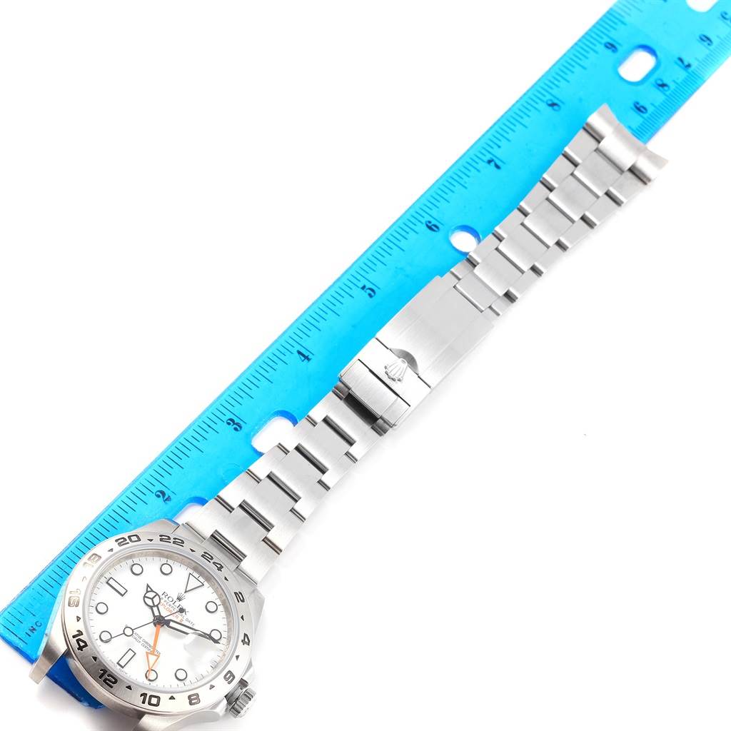 The image shows a flatly laid Rolex Explorer 216570 Men's Stainless Steel White Dial 216570 Men's Stainless Steel White Dial watch with its bracelet against a blue ruler for measurement.