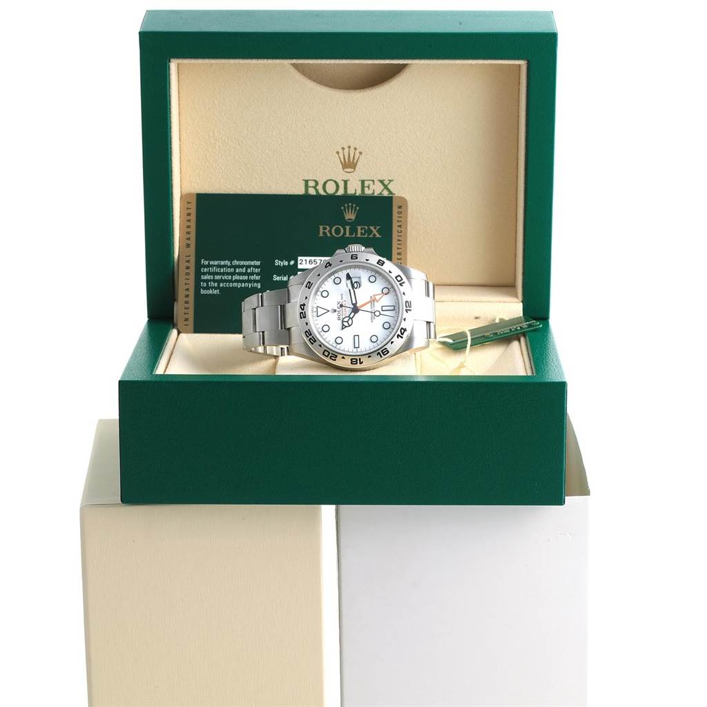 The Rolex Explorer 216570 Men's Stainless Steel White Dial 216570 Men's Stainless Steel White Dial watch is displayed front-facing in its green box, alongside warranty certification.