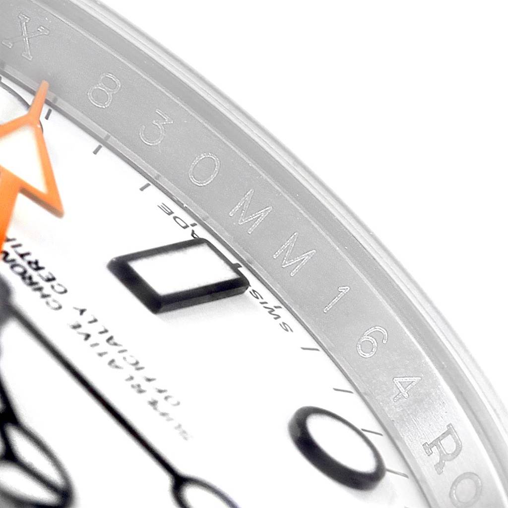 This close-up image of a Rolex Explorer 216570 Men's Stainless Steel White Dial 216570 Men's Stainless Steel White Dial watch shows the bezel, part of the dial, and hour markers.