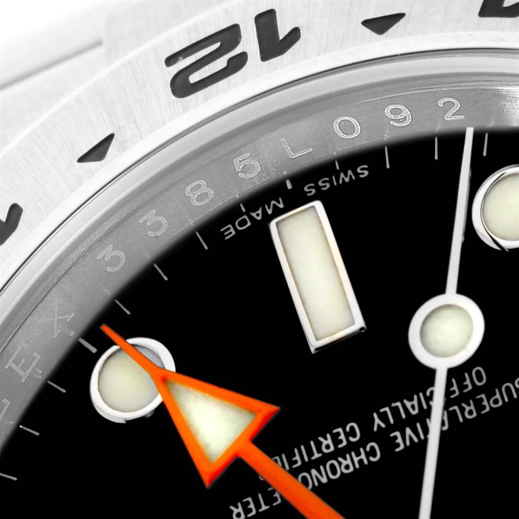 This close-up angle of the Rolex Explorer 216570 Men's Stainless Steel Black Dial 216570 Men's Stainless Steel Black Dial watch showcases the bezel, part of the dial, and the orange hand.