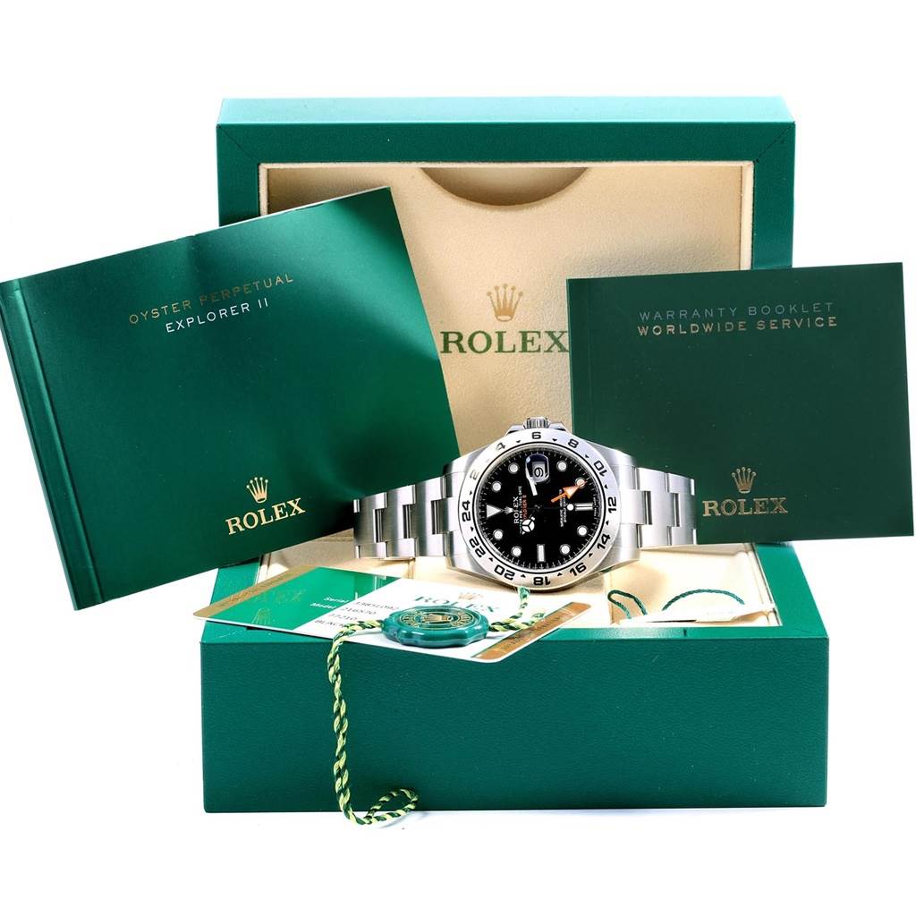 The image shows a Rolex Explorer 216570 Men's Stainless Steel Black Dial 216570 Men's Stainless Steel Black Dial watch and its accessories, including booklets, warranty card, and a tag, from a front angle.