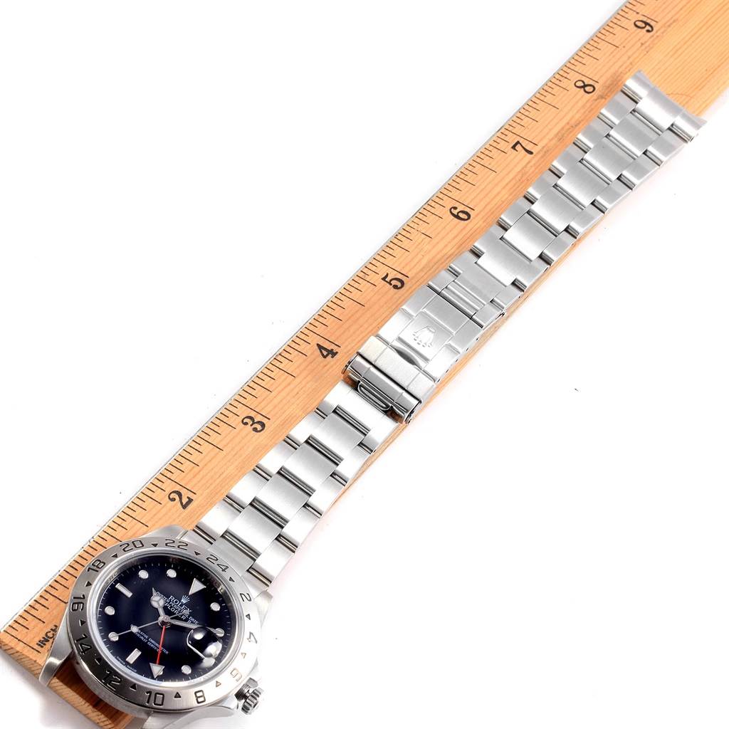 The image shows a flat-lay view of a Rolex Explorer 16570 Men's Stainless Steel Black Dial 16570 Men's Stainless Steel Black Dial watch with its stainless steel bracelet next to a ruler for size reference.